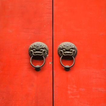 red wooden door or gate and old vintage lion head metal door ring handle knocker