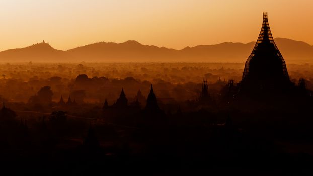 The sun is rising over the temples of Bagan