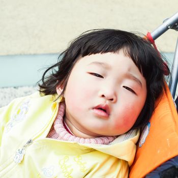 SHIANGHAI, CHINA - April 8, 2011 :  Chinese cute girl kid with baby carriage in the park