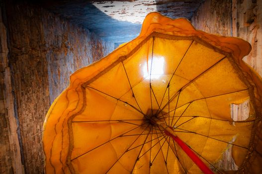 Orange umbrella against sunlight in temple Angkor Wat