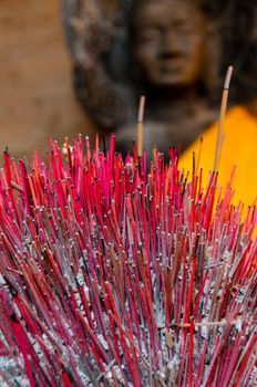 Incense sticks with Buddha in the back seen in a temple of Angkor Wat