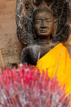 Incense sticks with Buddha in the back seen in a temple of Angkor Wat