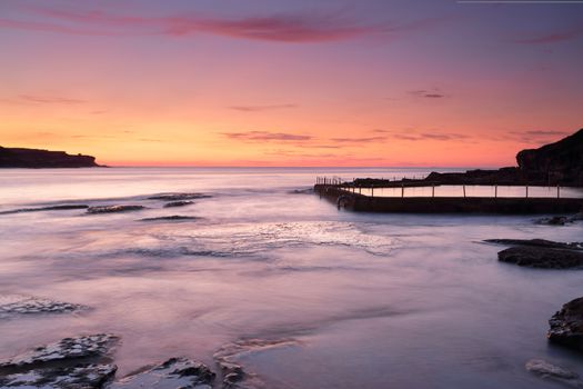Magnificent sunrise of rich orange and red hues over Malabar near Sydney with Malabar ocean pool to the right. 