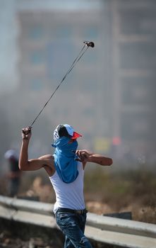 WEST BANK, Ramallah: A young masked Palestinian with a sling-shot is seen in a street of northern Ramallah, West Bank, on October 17, 2015, during clashes with Israeli army near Beit El Israeli settlement.