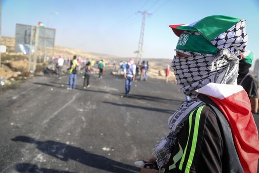 WEST BANK, Ramallah: A young masked Palestinian is seen in a street of northern Ramallah, West Bank, on October 17, 2015, during clashes with Israeli army near Beit El Israeli settlement.