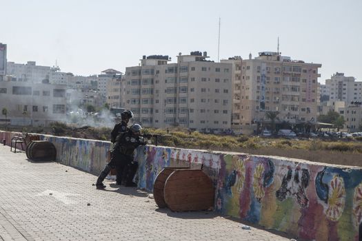 WEST BANK, Ramallah: Two Israeli soldiers shoot canisters with rubber coated steel bullets at Palestinian youth during clashes in Al Bireh, near the Israeli settlement of Beit El in the West Bank on October 16, 2015.