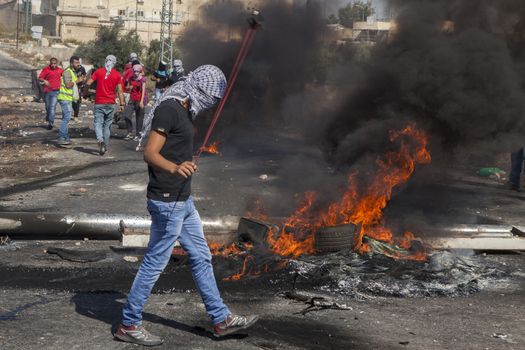 WEST BANK, Ramallah: A Palestinian plays with a slingshot during clashes between the Israeli army and Palestinian youth near the Israeli settlement of Beit El in the West Bank on October 16, 2015.