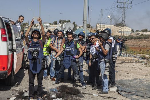 WEST BANK, Ramallah: Palestinian journalistes take a selfie in full protection gear during clashes between the Israeli army and Palestinian youth, near the Israeli settlement of Beit El in the West Bank on October 16, 2015.