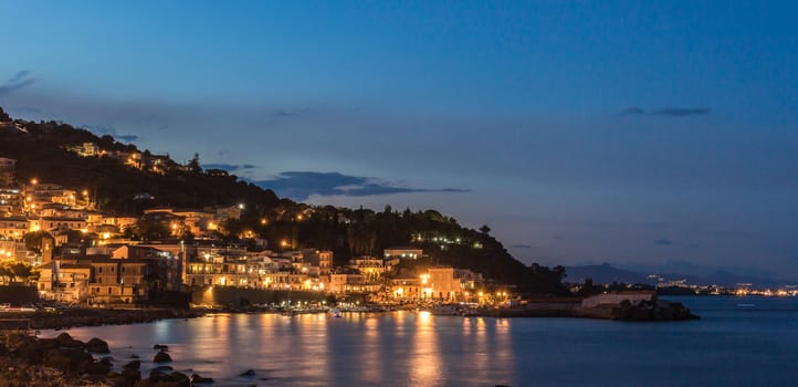 Waterfront street and old buildings by night.