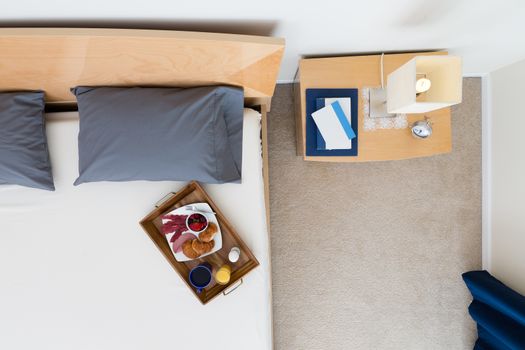 High Angle View of Breakfast Tray on Bed in Tastefully Decorated Bedroom with Night Stand