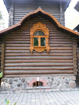 wooden building with carved shutters on a stone foundation