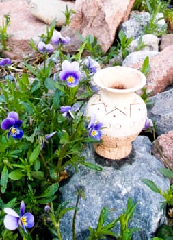 ceramic jug standing on a rock in florets