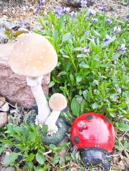 decorative mushroom and ladybug in the garden on a background of flowers