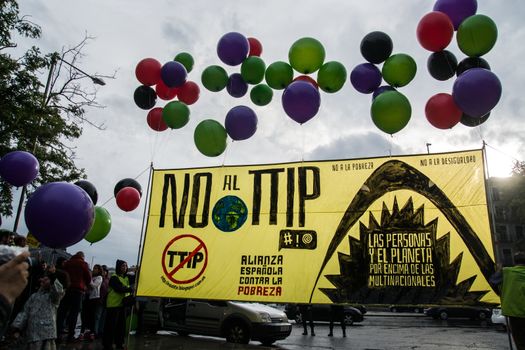 SPAIN, Madrid: Balloons and posters are displayed during a protest against the Transatlantic Trade and Investment Partnership in Madrid, Spain on October 17, 2015. Leaders are still reaching an agreement on the TTIP, a deal designed to boost the US economy and European Union by removing tariffs and other barriers to trade and foreign investment. Protesters argue the TTIP will support corporations at the expense of citizens, increase poverty and inequality and harm the environment. 