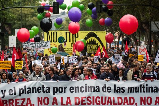 SPAIN, Madrid: Hundreds attend a protest against the Transatlantic Trade and Investment Partnership in Madrid, Spain on October 17, 2015. Leaders are still reaching an agreement on the TTIP, a deal designed to boost the US economy and European Union by removing tariffs and other barriers to trade and foreign investment. Protesters argue the TTIP will support corporations at the expense of citizens, increase poverty and inequality and harm the environment. 