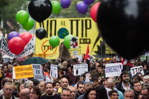 SPAIN, Madrid: Hundreds attend a protest against the Transatlantic Trade and Investment Partnership in Madrid, Spain on October 17, 2015. Leaders are still reaching an agreement on the TTIP, a deal designed to boost the US economy and European Union by removing tariffs and other barriers to trade and foreign investment. Protesters argue the TTIP will support corporations at the expense of citizens, increase poverty and inequality and harm the environment. 