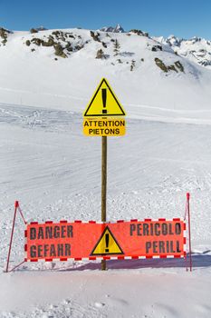 Pedestrians passing a ski slope in the mountains