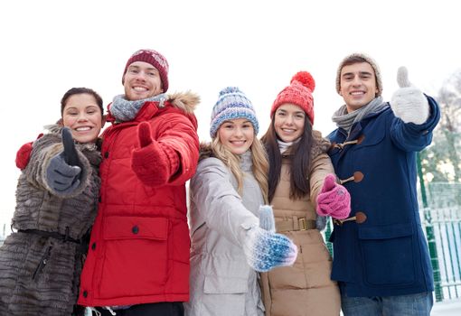 love, relationship, season, friendship and people concept - group of smiling men and women walking in winter forest