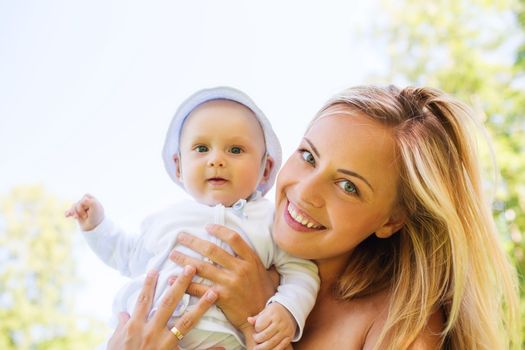 family, child and parenthood concept - happy mother with little baby outdoors