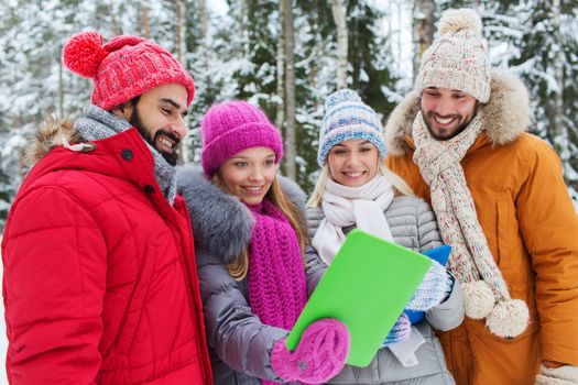 technology, season, friendship and people concept - group of smiling men and women taking selfie tablet pc computer in winter forest