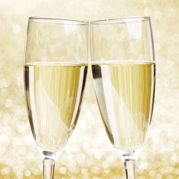 Flutes of champagne on golden holiday bokeh background