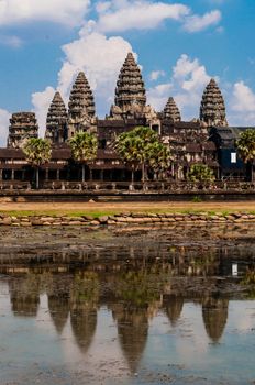 Front of Angkor Wat with reflection in water and a blue sky above