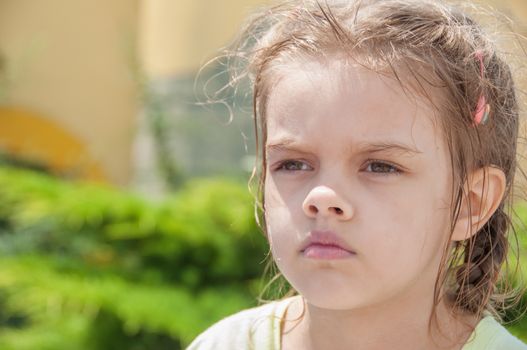 Portrait of a tired six year old girl with wet hair and a sad look