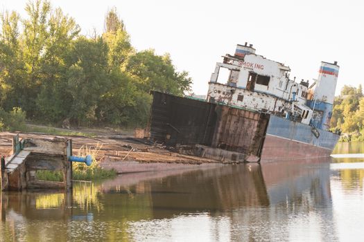 Volgograd, Russia - August 27, 2015: Dismantled transport ship on the river bank