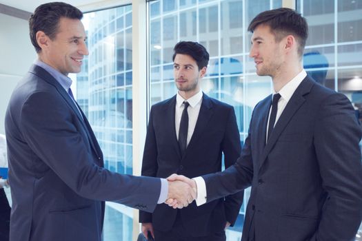 Business people shaking hands, finishing up a meeting in office