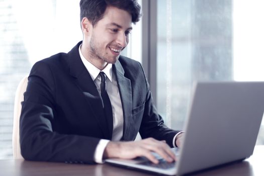 Busy businessman in office working on his laptop.