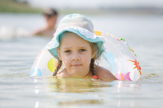 Four-year girl with the Europeans bathed swimming laps in the river