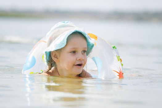 Four-year girl with the Europeans bathed swimming laps in the river