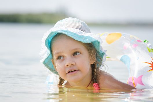 Four-year girl with the Europeans bathed swimming laps in the river