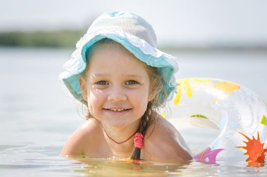 Four-year girl with the Europeans bathed swimming laps in the river