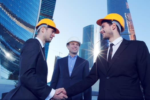 Investor and contractor shaking hands, view from below