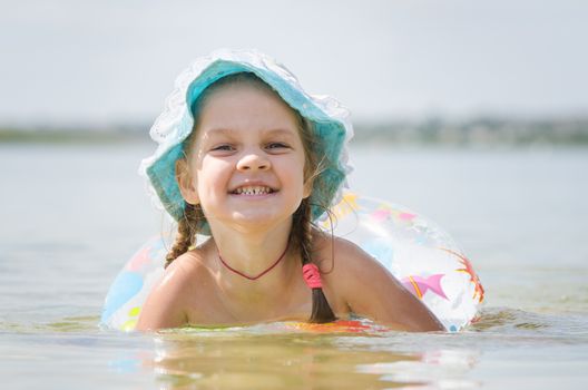 Four-year girl with the Europeans bathed swimming laps in the river