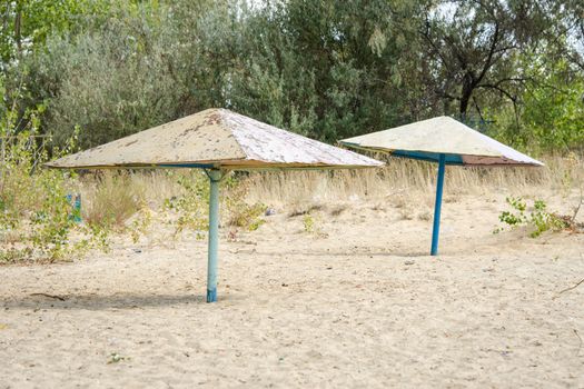 Old metal beach umbrellas on the sandy beach