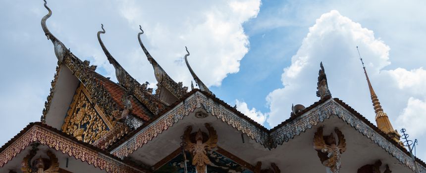 Roof of temple in Laos with blue sky and clouds in close to Luang Prabang