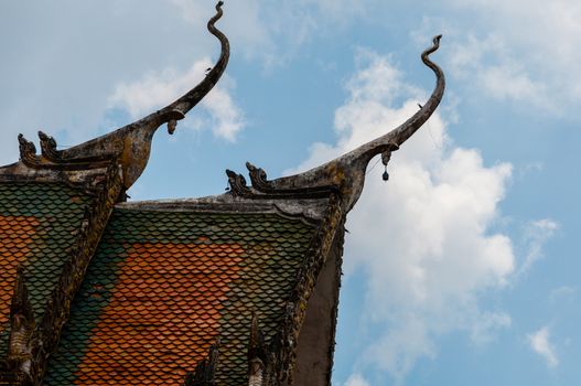 Roof of temple in Laos with blue sky and clouds in close to Luang Prabang