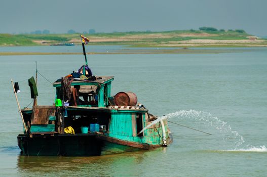 Green boat on Irrawaddy river close to Mandalay Burma Myanmar