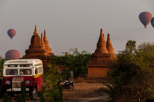 Bus Pagoda Stupa and hot air balloon over Bagan in Myanmar Burma