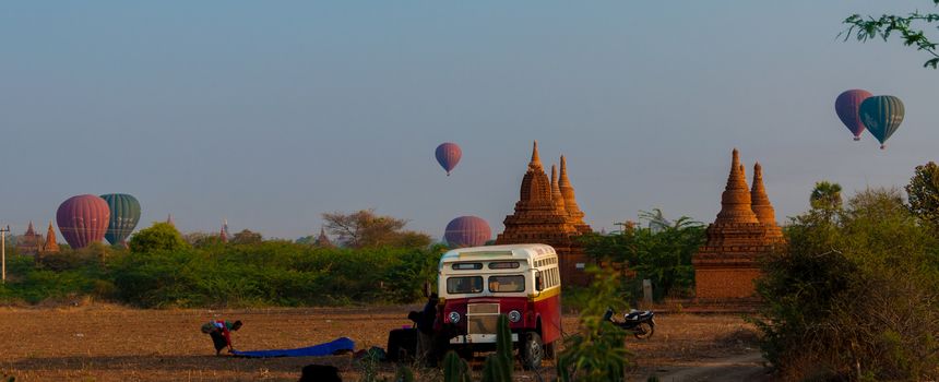 Bus Pagoda Stupa and hot air balloon over Bagan in Myanmar Burma