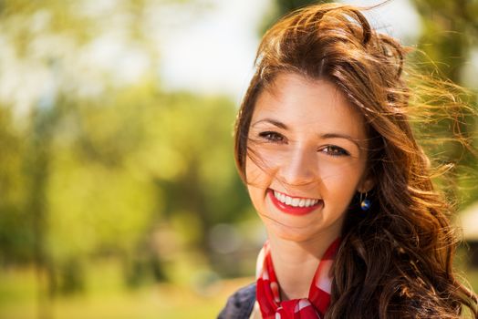 Portrait of Smiling Young Woman in The Nature with Summer Breeze in the Hair.
