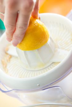 Squeezing lemon juice with an electric citrus juicer.