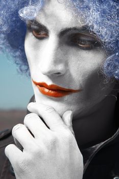 Pensive clown with blue wig. Vertical colorful portrait