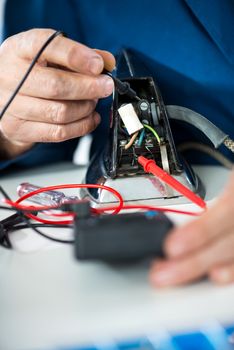 Electrician using voltmeter for Testing Voltage on old iron. Close Up.