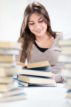 Beautiful Student girl learning between many books. Selective focus.