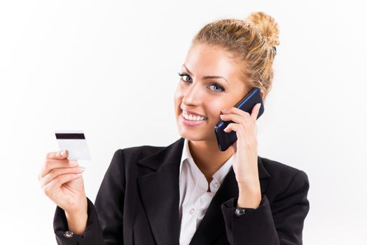 Businesswoman telephoning and holding a credit card.