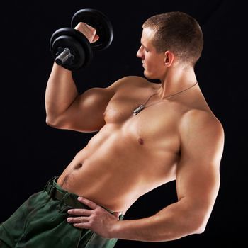 Young muscular man lifts a weight with biceps.