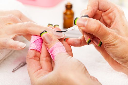 Manicure treatment in cosmetic salon.